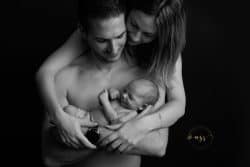 Photo en noir et blanc d'un papa ressemblant à l'acteur Tom Ellis de la série "Lucifer" en train de regarder avec amour son bébé - Azemard Stéphanie, photographe de Montpellier