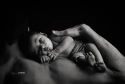 Une scène pleine d'amour : un père tenant délicatement son bébé à la verticale, une photo touchante qui capte l'instant précieux