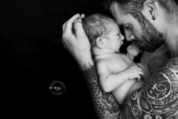 Un moment capturé pour l'éternité : une touchante photo noir et blanc d'un père et de son fils, immortalisée par Azémard Stéphanie, experte en photographie de nouveau-né dans l'Hérault.