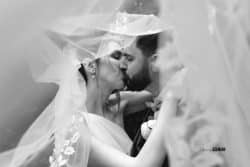 Mariés échangeant un doux baiser en noir et blanc, photographiés par Stéphanie Azemard, capturant un moment d’émotion intemporelle."