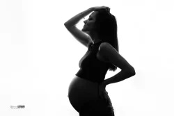 Silhouette en contre-jour d'une femme enceinte en noir et blanc, photographiée en studio par Stéphanie Azemard à Montpellier.