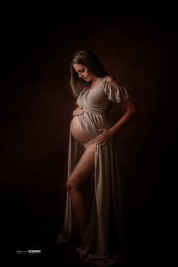 Femme enceinte en robe fluide posant dans une ambiance douce et artistique, photographie de maternité réalisée par Stéphanie Azemard à Montpellier.