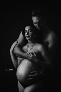 Portrait artistique en noir et blanc d’un couple enlacé mettant en valeur le ventre rond de la future maman, réalisé par Stéphanie Azemard en studio à Montpellier.